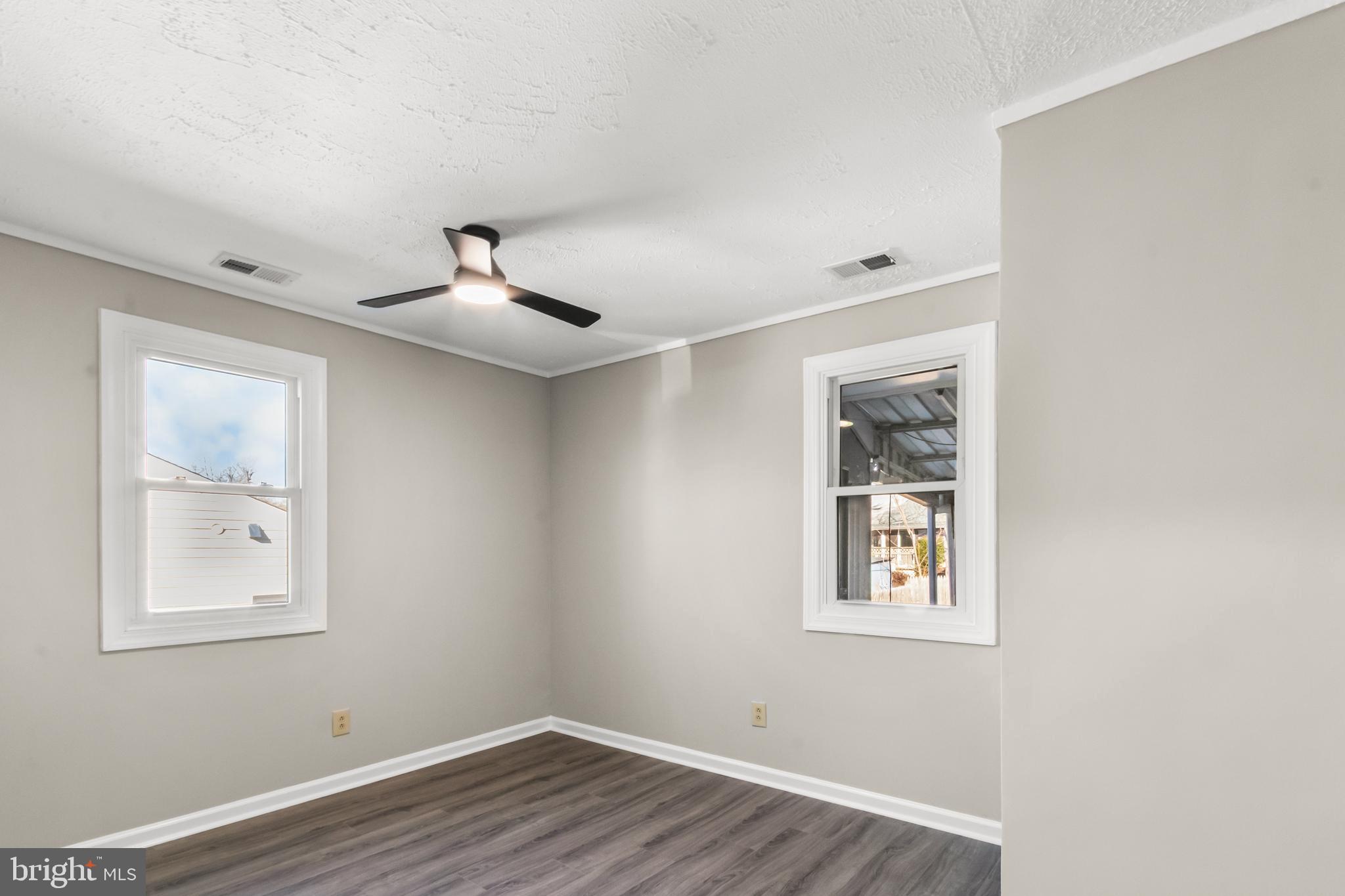 7736 Oxman Road Landover, MD 20785 - Photo 12 of 30 a view of an empty room with wooden floor and a window
