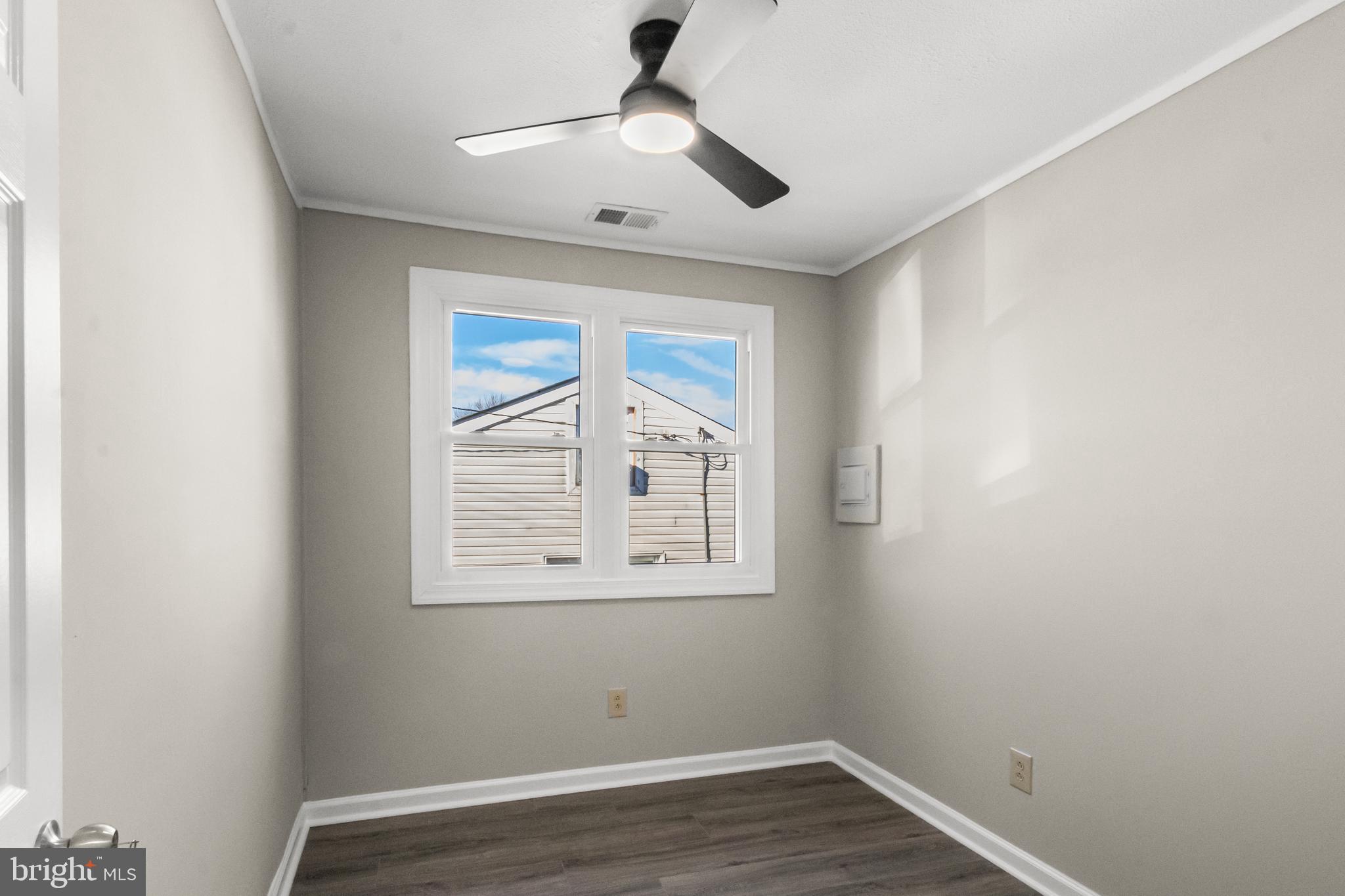 7736 Oxman Road Landover, MD 20785 - Photo 14 of 30 an empty room with wooden floor ceiling fan and windows