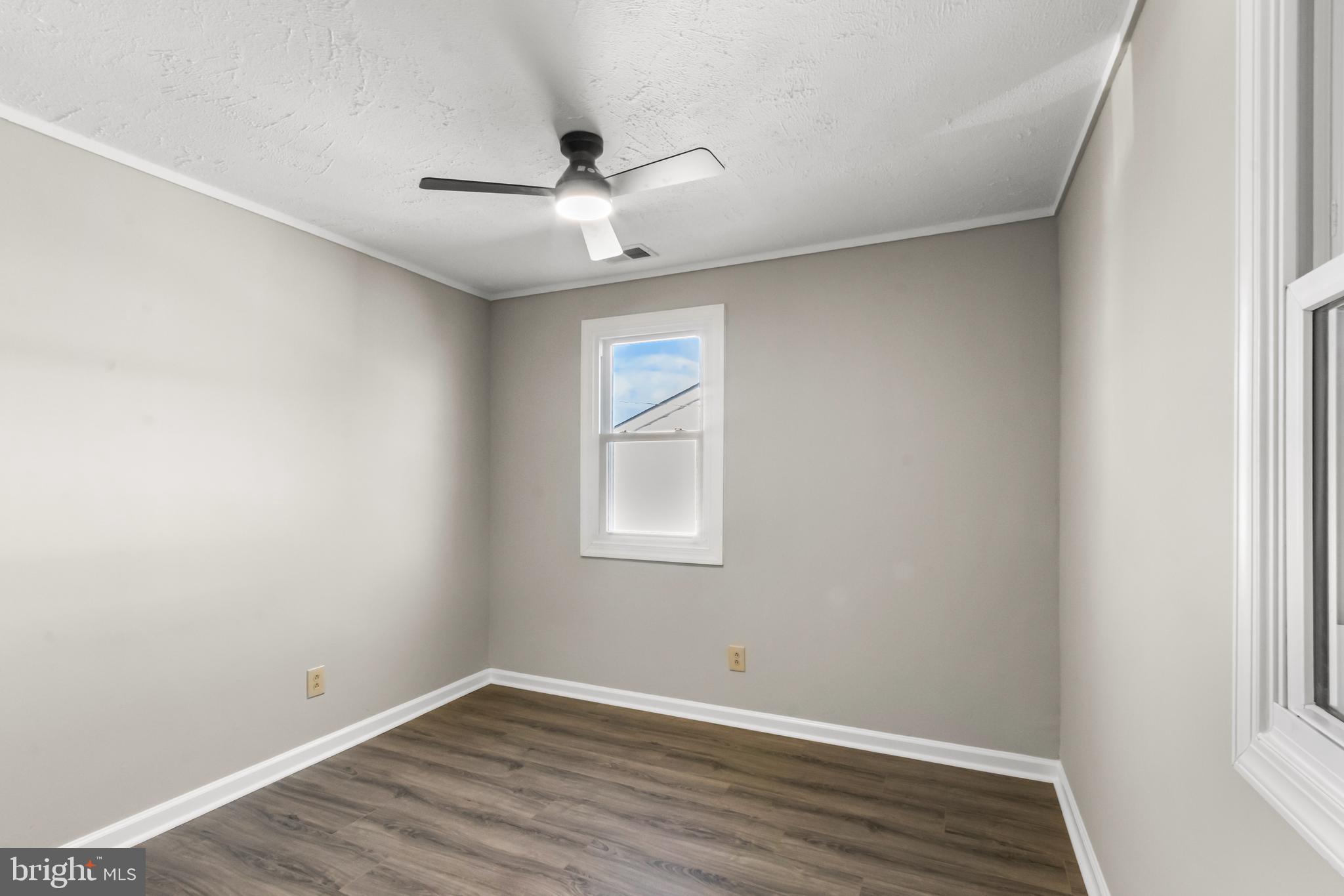 7736 Oxman Road Landover, MD 20785 - Photo 16 of 30 an empty room with wooden floor ceiling fan and windows