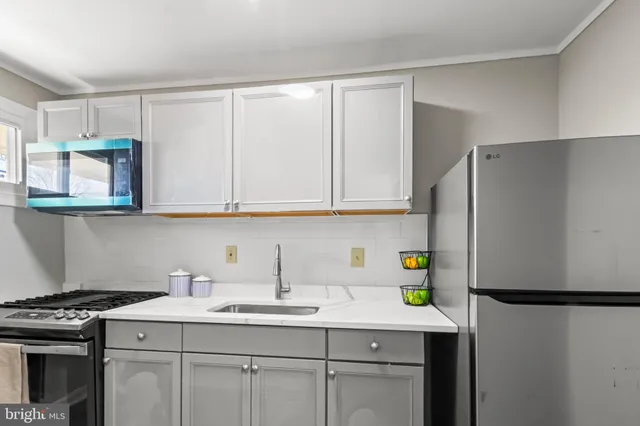 a kitchen with a sink a refrigerator and cabinets