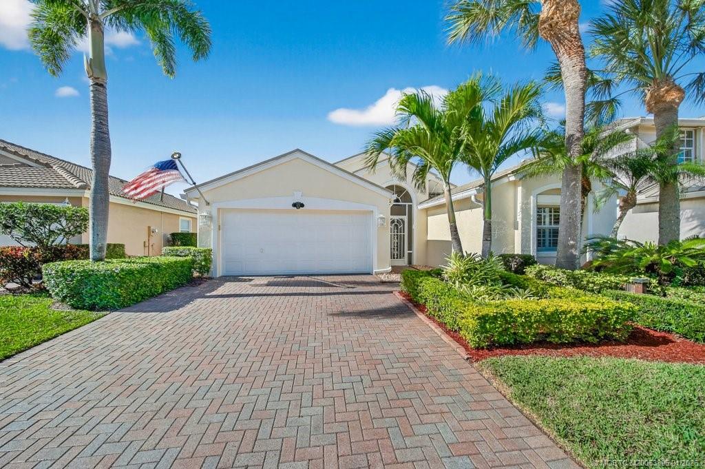 871 Southeast Westminster Place Stuart, FL 34997 - Photo 2 of 38 a front view of a house with a yard and potted plants