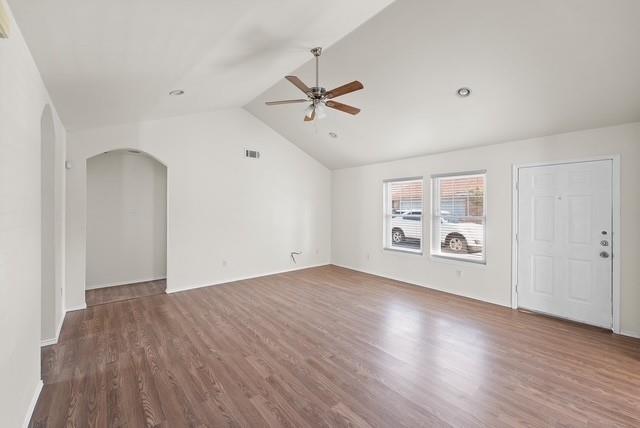 13741 Biggs Street Dallas, TX 75253 - Photo 5 of 17 an empty room with wooden floor ceiling fan and windows