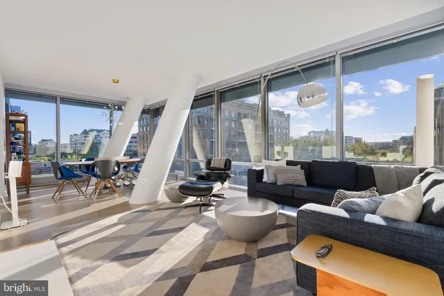 a living room with furniture and floor to ceiling windows