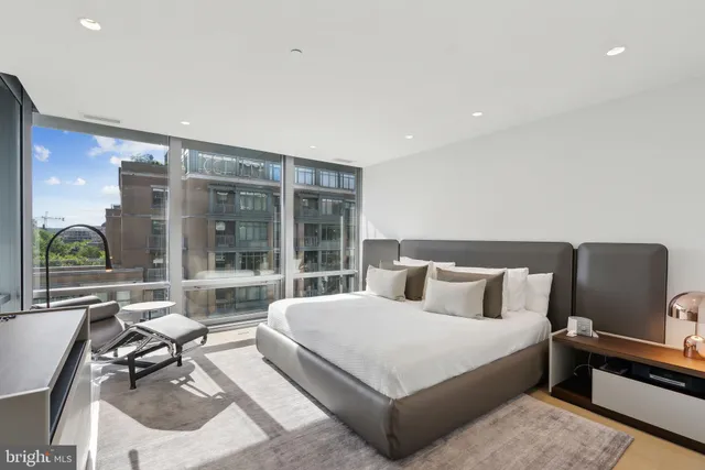 a living room with furniture a flat screen tv and a floor to ceiling window