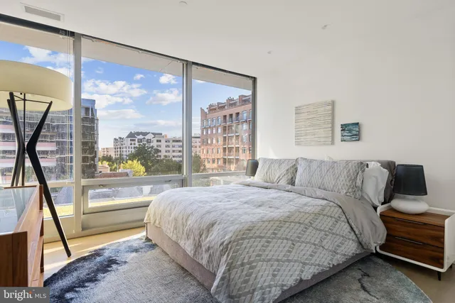 a bedroom with a large window and a balcony