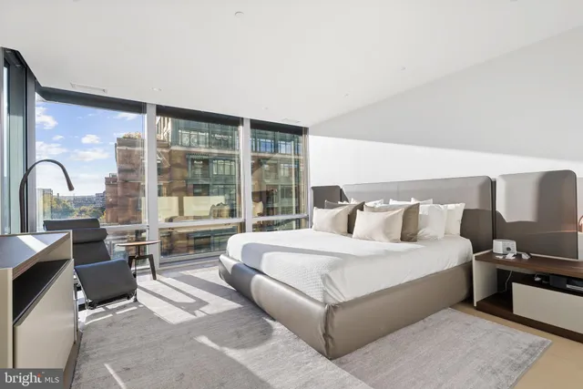 a bedroom with a bed and a large window