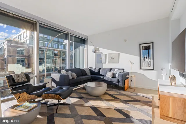 a living room with furniture and a floor to ceiling window