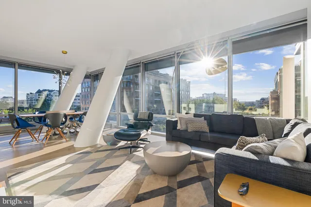 a view of a livingroom with furniture and floor to ceiling window