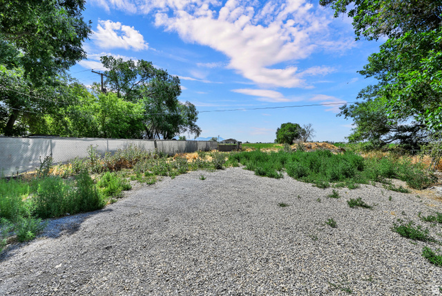 716 East Factory Street Garland, UT 84312 - Photo 29 of 30 Gravel surface with surrounding foliage and a chain link fence