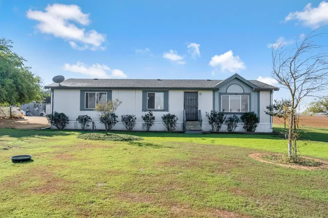 a front view of house with yard and swimming pool