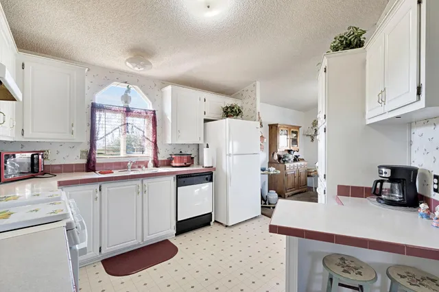 a kitchen with a sink a refrigerator and cabinets