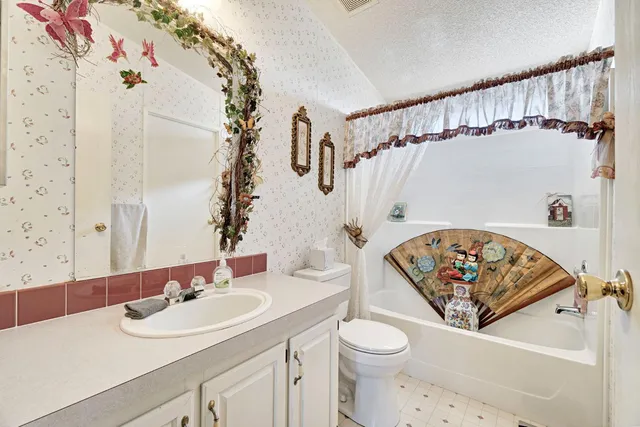 a bathroom with a sink a toilet and shower curtain