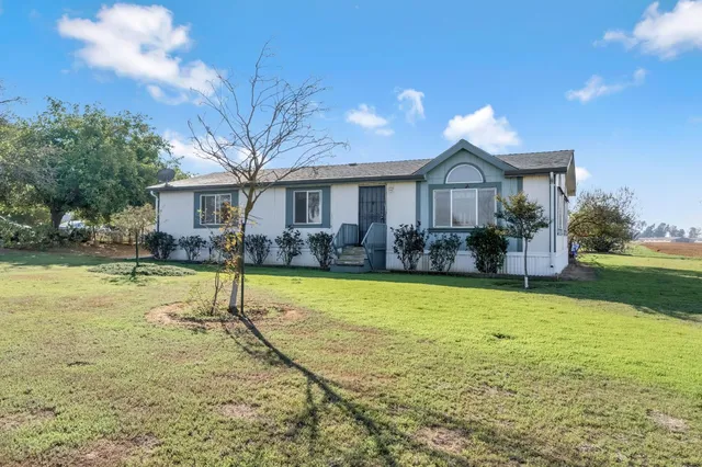 a view of a house with swimming pool and a yard