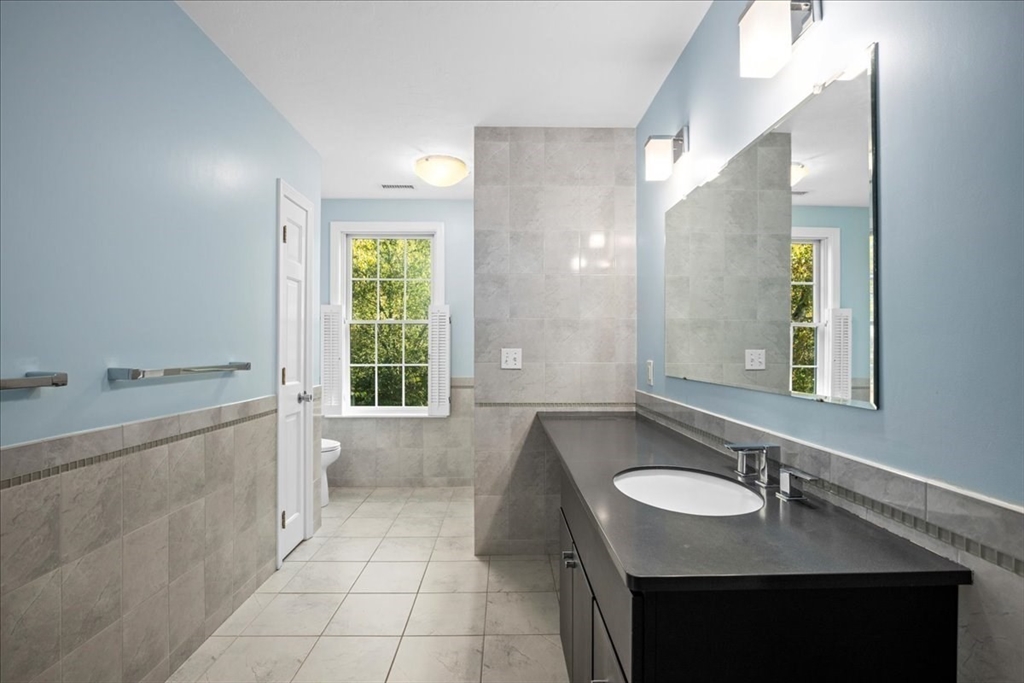 8 Arch Street Shrewsbury, MA 01545 - Photo 31 of 42 a bathroom with a granite countertop bathtub sink vanity and mirror