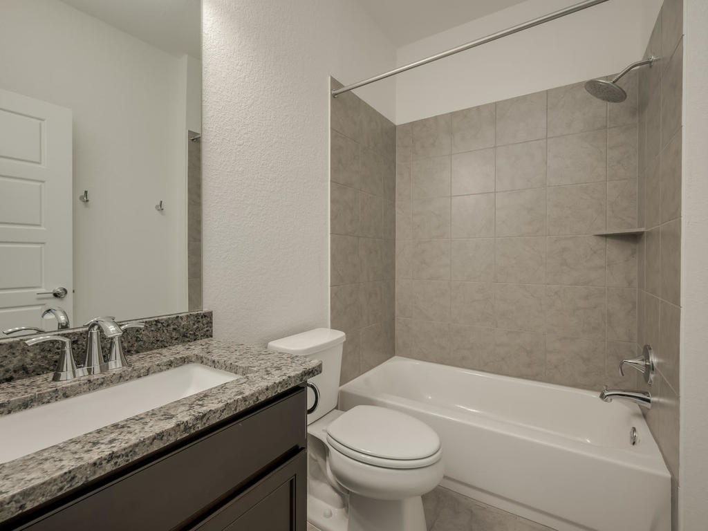 12327 Maypole Bend Austin, TX 78717 - Photo 28 of 30 a bathroom with a granite countertop sink a toilet and bathtub