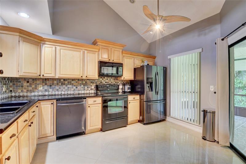 9316 Ketay Circle Boca Raton, FL 33428 - Photo 7 of 30 a kitchen with stainless steel appliances granite countertop a refrigerator a stove a sink and a microwave