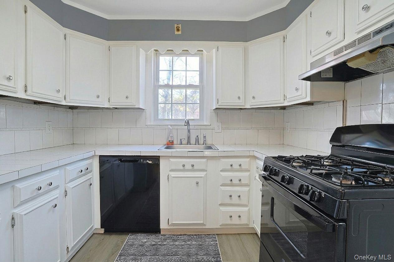 43 John Alden Road New Rochelle, NY 10801 - Photo 13 of 28 a kitchen with white cabinets and a stove