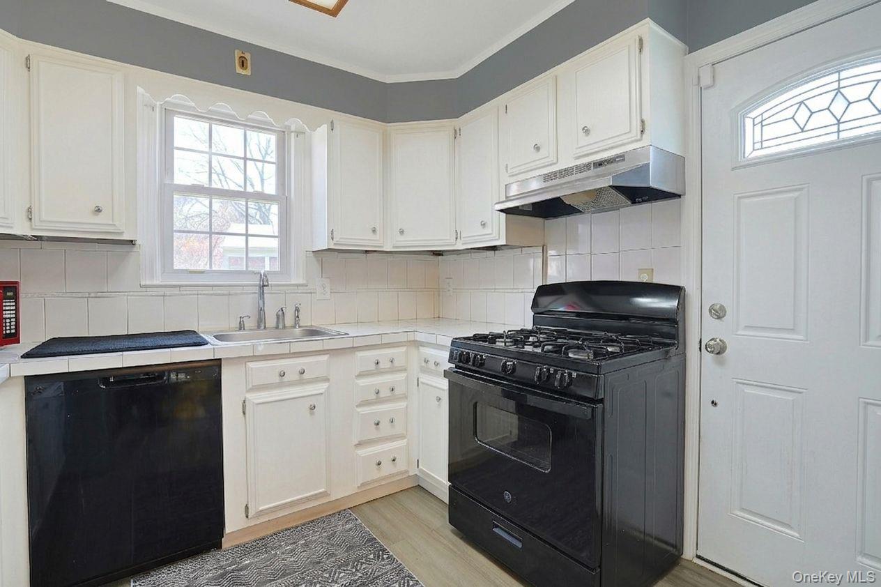 43 John Alden Road New Rochelle, NY 10801 - Photo 14 of 28 a kitchen with granite countertop white cabinets and stainless steel appliances