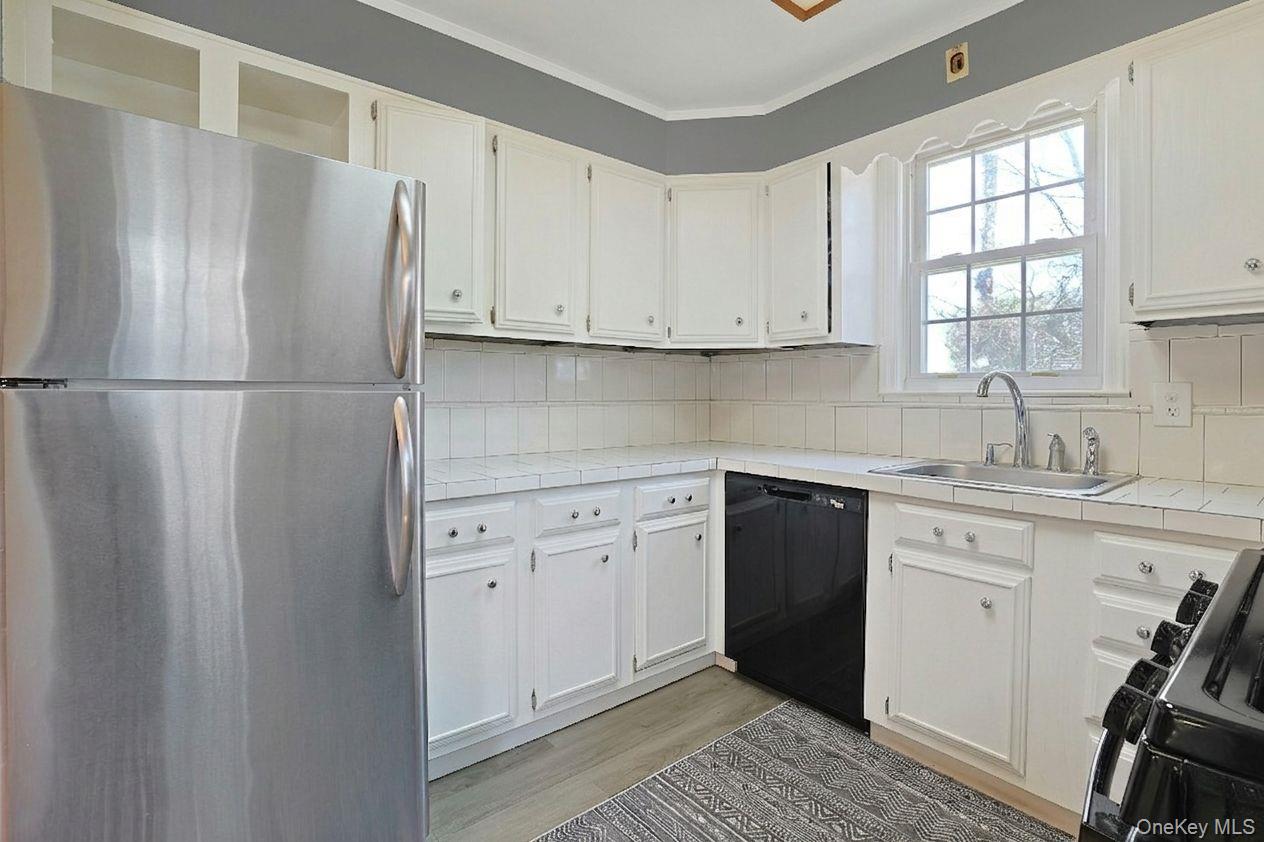 43 John Alden Road New Rochelle, NY 10801 - Photo 15 of 28 a kitchen with a white cabinets and a refrigerator