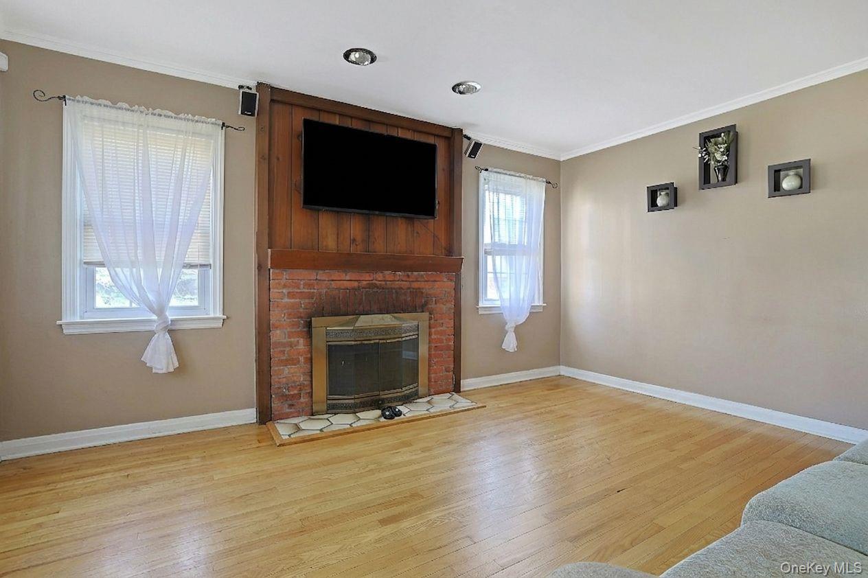43 John Alden Road New Rochelle, NY 10801 - Photo 8 of 28 a view of empty room with wooden floor and fireplace