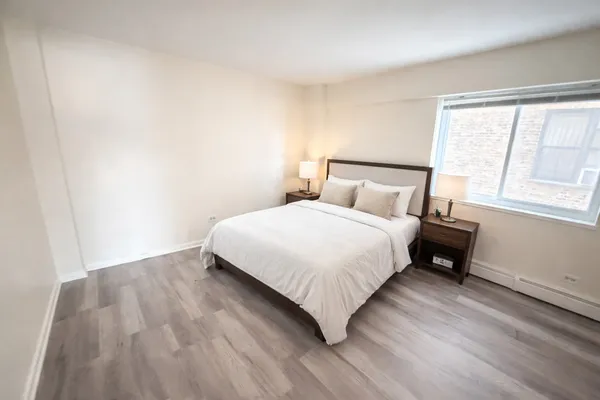 a bedroom with a bed lamp and a window