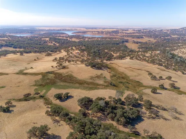 an aerial view of residential houses with outdoor space and ocean view