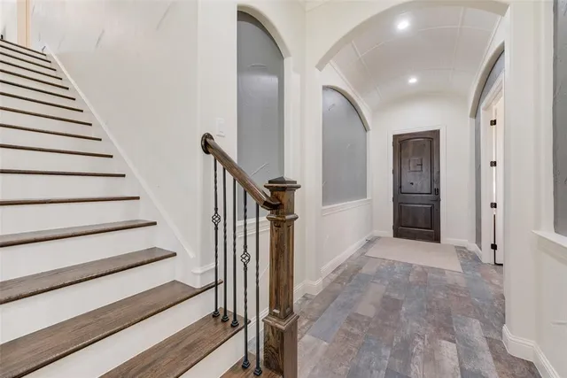 a view of a hallway with wooden floor and entryway