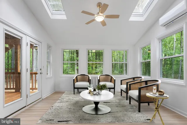 a living room with furniture a large window and a chandelier