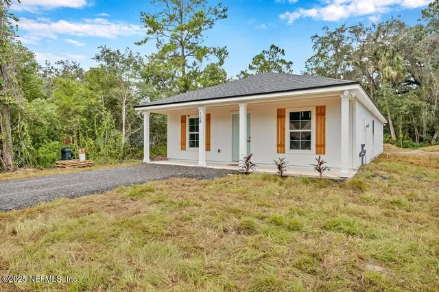 a view of a house with a yard and potted plants