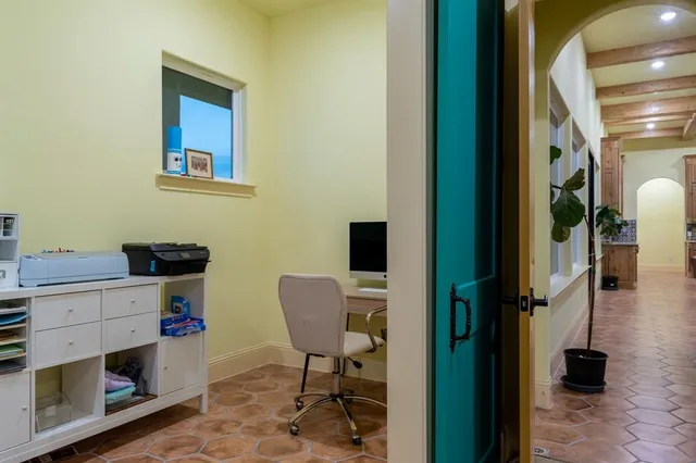 a view of a workspace with furniture and a window