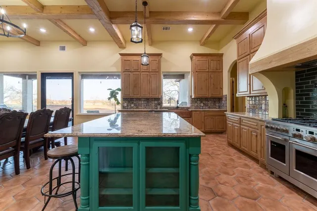 a kitchen with kitchen island a large counter top space appliances and cabinets