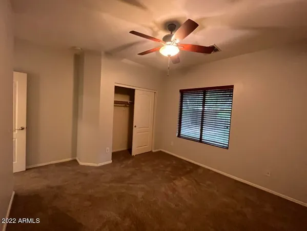 an empty room with a window and a ceiling fan
