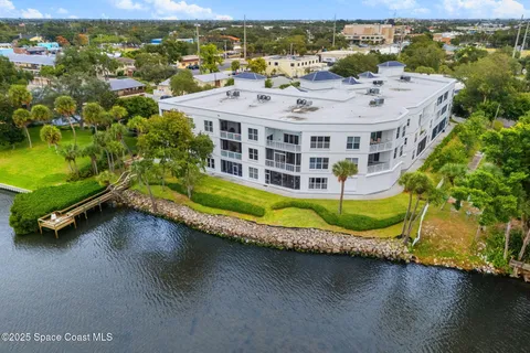 an aerial view of a house with a garden and lake view