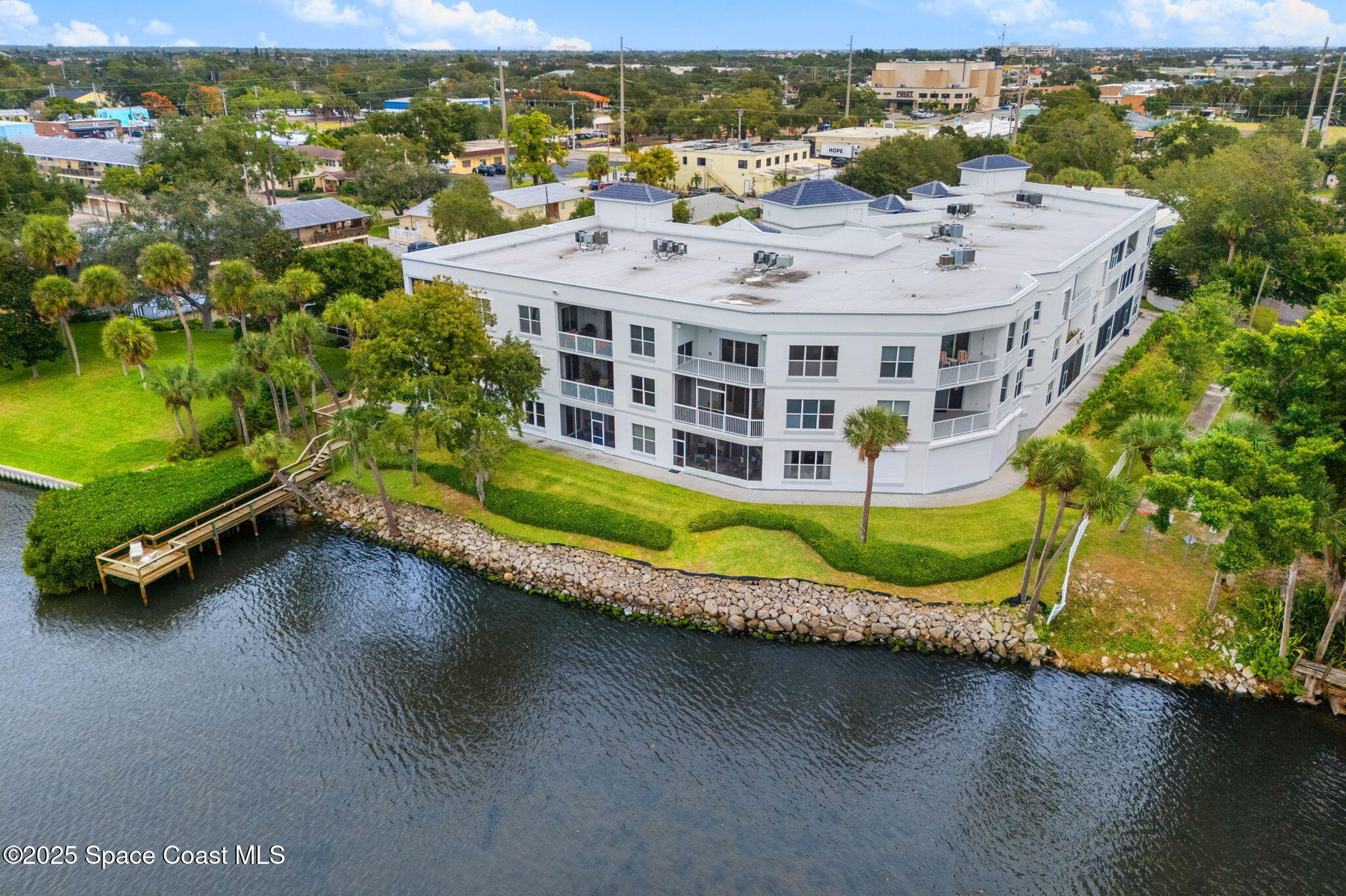 an aerial view of a house with a garden and lake view