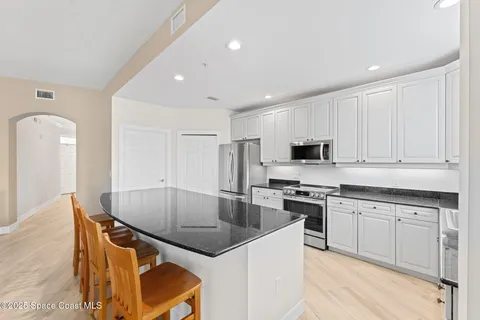 a kitchen with stainless steel appliances granite countertop a sink a stove and cabinets