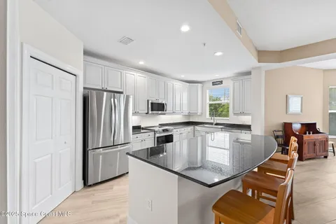 a kitchen with stainless steel appliances granite countertop a refrigerator sink and stove
