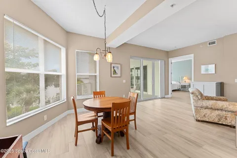 a dining room with furniture a chandelier and wooden floor