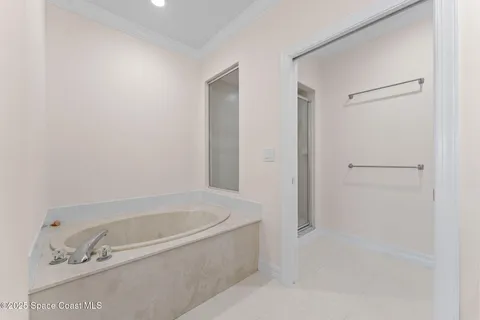 a white bath tub sitting next to a shower