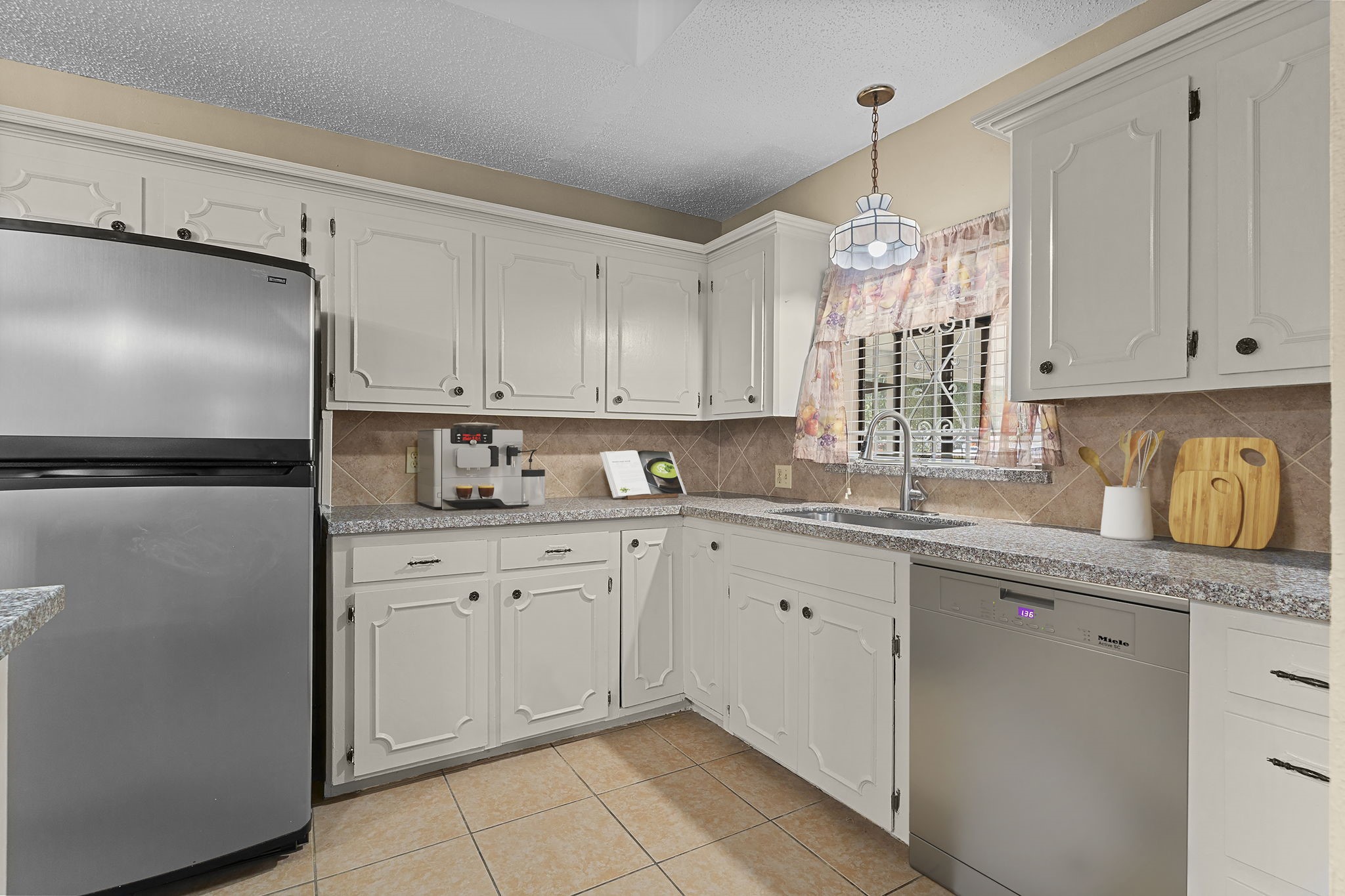 4114 Connorvale Road Houston, TX 77039 - Photo 6 of 41 a kitchen with granite countertop white cabinets white appliances a sink and a window