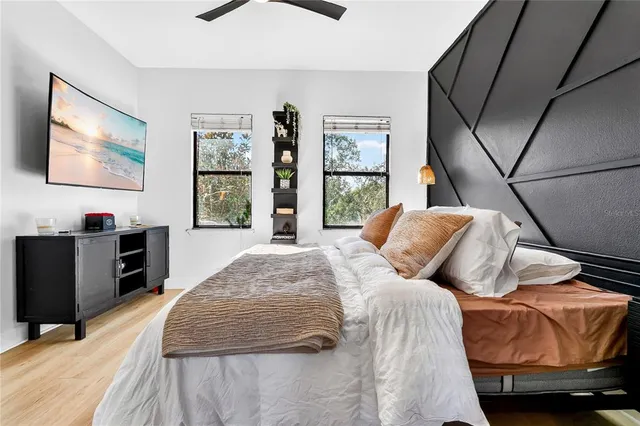 a bedroom with bed and a flat tv screen