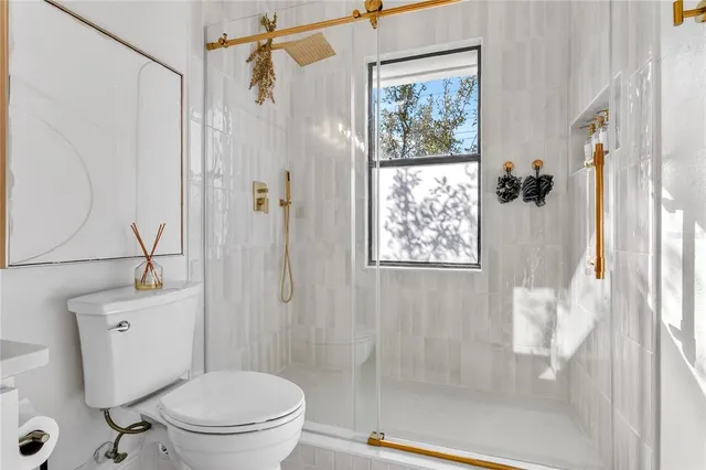 a bathroom with a shower a toilet and a sink