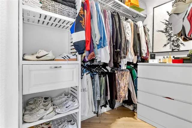a view of walk in closet with clothes and shoes