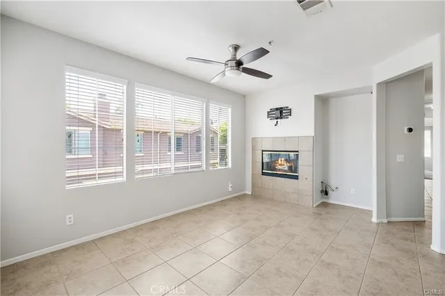 a view of an empty room with a window and kitchen view
