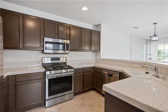 a kitchen with a sink stove top oven and cabinets