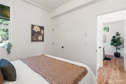 a bedroom with a bed and a potted plant