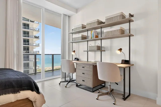 a view of a workspace with furniture and a window