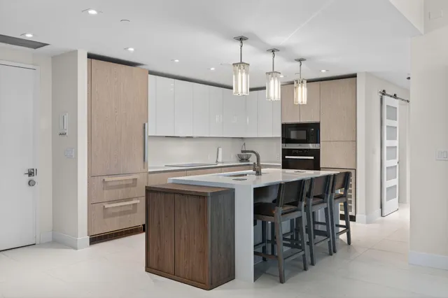 a kitchen with kitchen island a sink stove and refrigerator