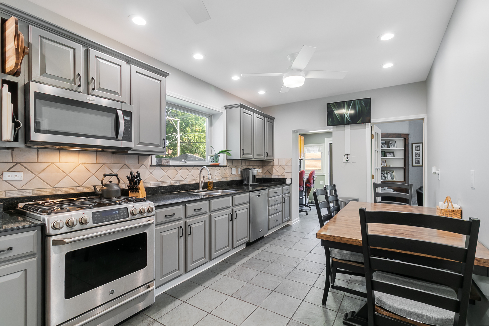 10337 South Hamilton Avenue Chicago, IL 60643 - Photo 8 of 27 a kitchen with stainless steel appliances granite countertop a stove top oven a sink dishwasher a dining table and chairs with wooden floor