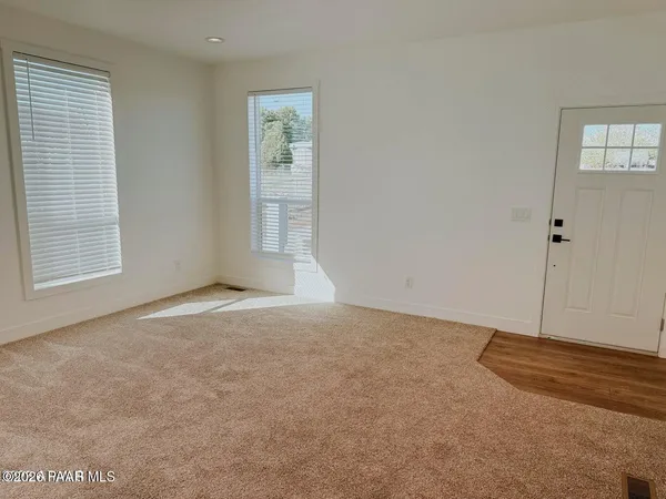 a view of an empty room with window and closet area