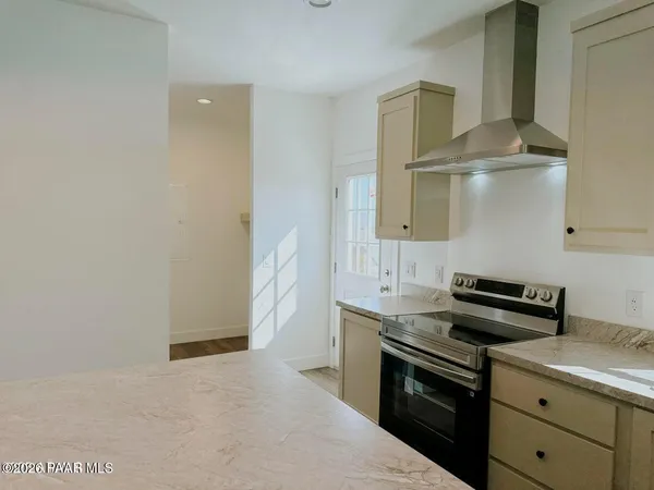 a kitchen with granite countertop a sink a stove and cabinets
